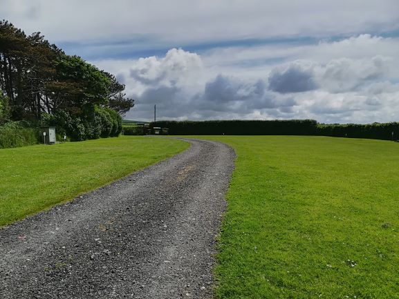 The front field, a wide grass pitch with a curving gravel track