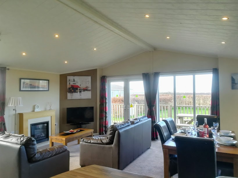 Sunset Lodge living and dining room, with an electric flame fire and patio doors