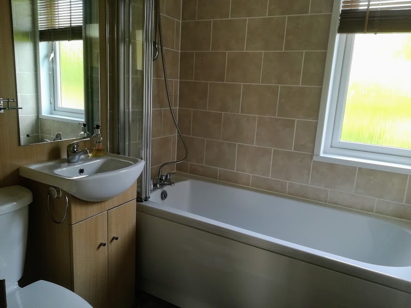 Sunset Lodge family bathroom, with bath and shower over