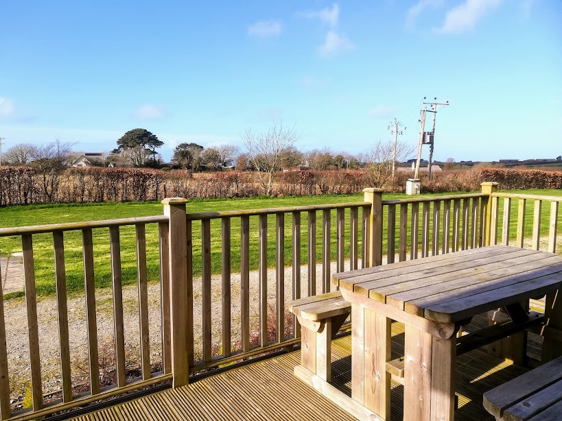 Picnic table on the Sunset Lodge deck, looking over the hedge