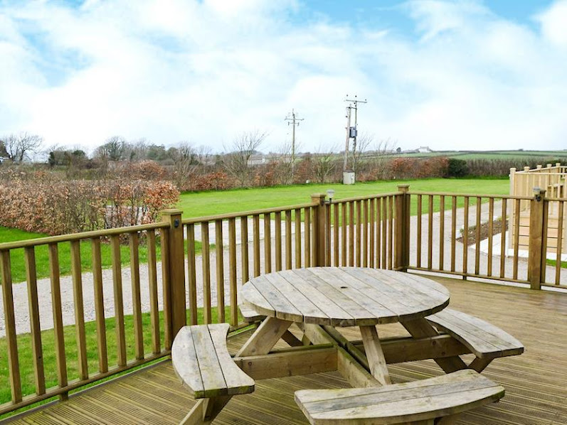 Round picnic table on the Hawks Roost deck, looking over the field