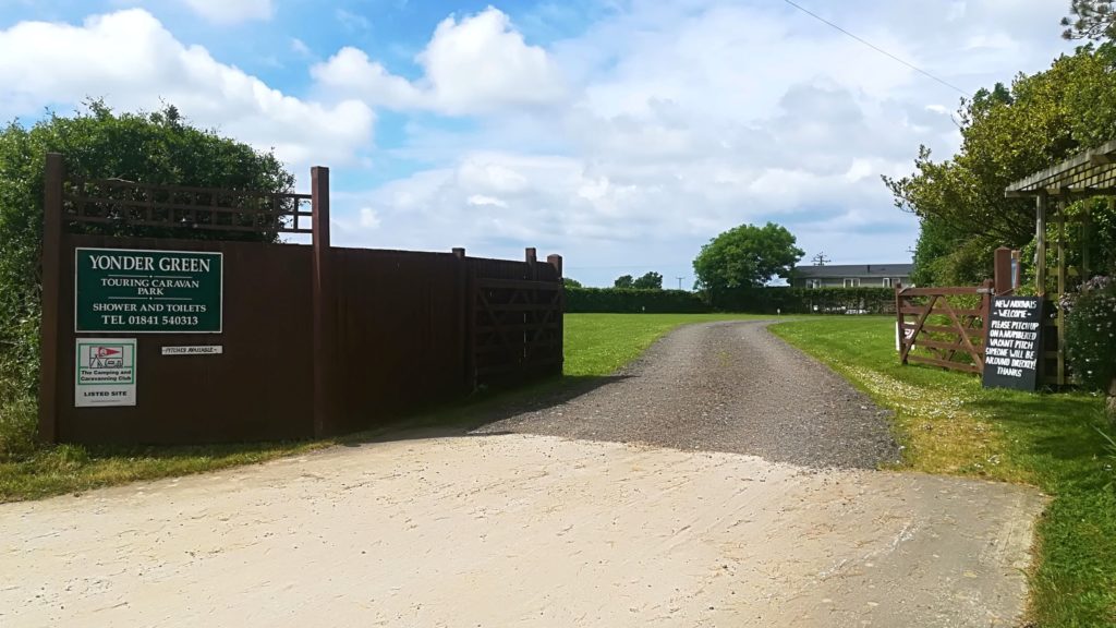 The entrance gate at Yonder Green, with the green sign reading touring caravan park, shower and toilets