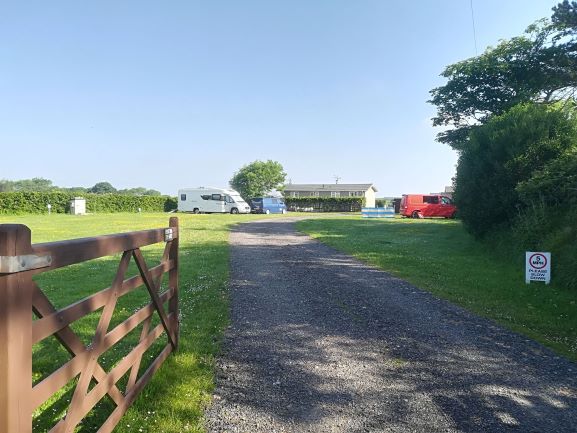 The drive into the park, grass pitches and a motorhome